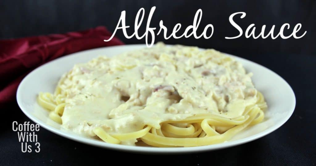 Fettuccine smothered with Alfred sauce and chicken with a red napkin in the background.