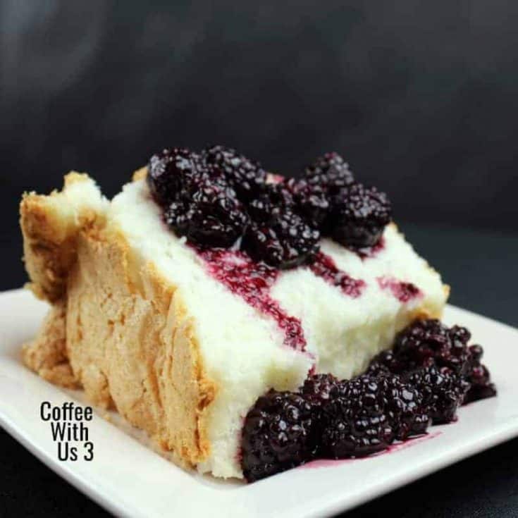 Slice of angel food cake with blackberry topping on a white plate