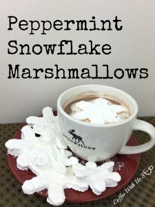 Peppermint Snowflake Marshmallows in a mug of hot cocoa on a red plate.