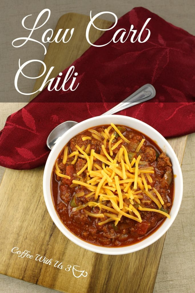 Low carb chili topped with cheese with spoon and napkin laying next to bowl.